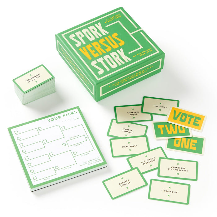 The Brass Monkey Spork Versus Stork Social Game is a green and yellow party set with a box, prompt cards, two Vote cards, a score sheet, and several game cards displayed on a white surface.