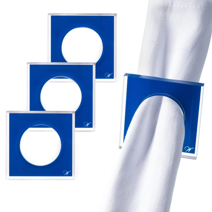 Blue square napkin rings with white circles displayed on a white napkin, showing elegant tabletop styling from Waterdale Collection.