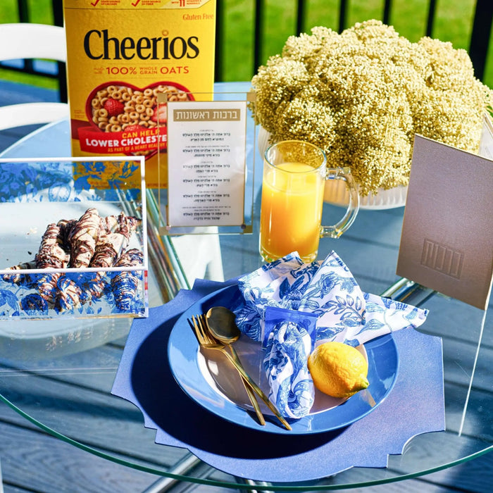 Gold square napkin rings displayed on a formal place setting with white flowers and breakfast items, elegant table decor by Waterdale Collection.