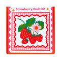Strawberry quilt kit in box packaging with red strawberries and a flower, on a white background.