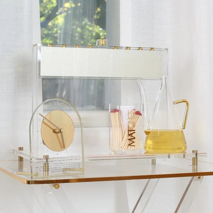 The Suspended Chanukah Set from the Waterdale Collection on a shelf - the floating Lucite menorah with its tray, clock and oil jug for Chanukah