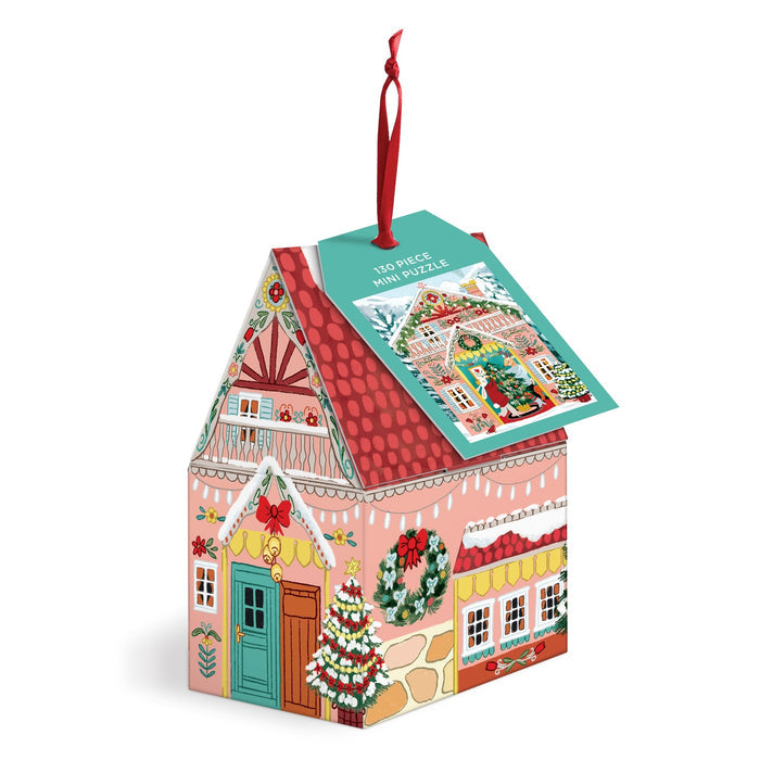 A decorative box shaped like a Swiss chalet with holiday designs, topped with a red ribbon and a tag that reads "130 Piece Ornament Puzzle" by Joanna Clay.