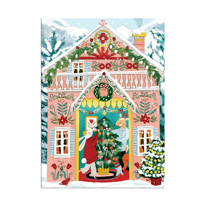 The Swiss Chalet 130 Piece Ornament Puzzle by Joanna Clay features a festive animal scene decorating a Christmas tree inside a pink gingerbread-style house adorned with garlands, wreaths, and snowy trees outside.