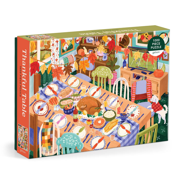 The Carla Ellis Thankful Table 1000 Piece Puzzle features a vibrant Thanksgiving dinner scene with a turkey, side dishes, fall décor, and a dog in a festive dining room.