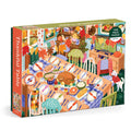 The Carla Ellis Thankful Table 1000 Piece Puzzle features a vibrant Thanksgiving dinner scene with a turkey, side dishes, fall décor, and a dog in a festive dining room.