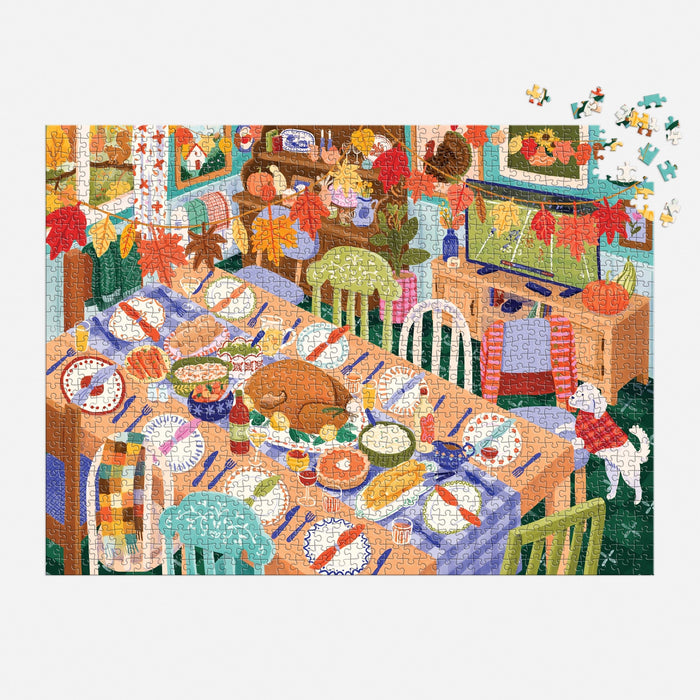 The Carla Ellis Thankful Table 1000 Piece Puzzle features a festive dining table with assorted dishes, mismatched chairs, fall decor, a dog by the window, and missing pieces in the top right for an engaging challenge.