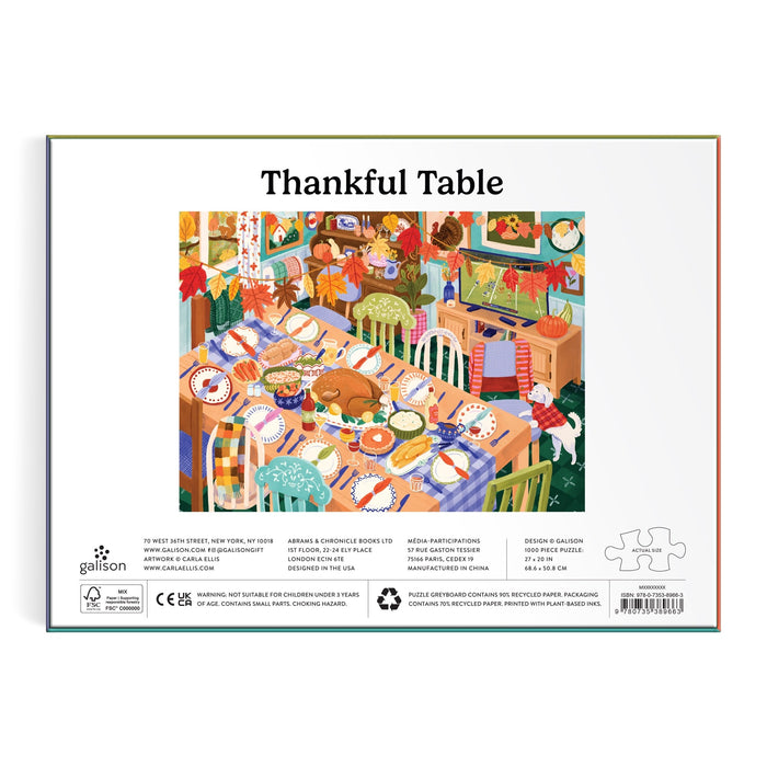 The Carla Ellis Thankful Table 1000 Piece Puzzle features a vibrant illustration of a festive dining room with a long table, mismatched chairs, pumpkins, dishes, and autumn decor. The box is labeled "Thankful Table.