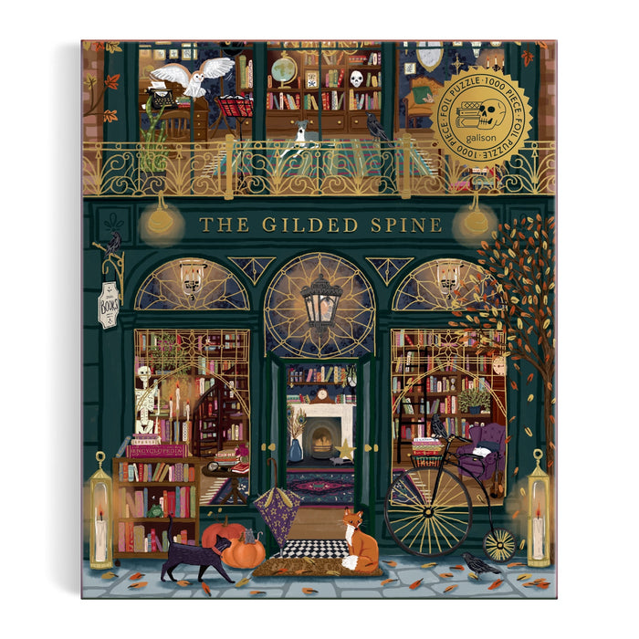 Illustration of The Gilded Spine bookstore with arched windows, bookshelves, pumpkins, cats, autumn leaves, and a glowing fireplace. A gold foil seal appears in the top right. The Gilded Spine 1000 Piece Foil Puzzle by Sally Wilson.
