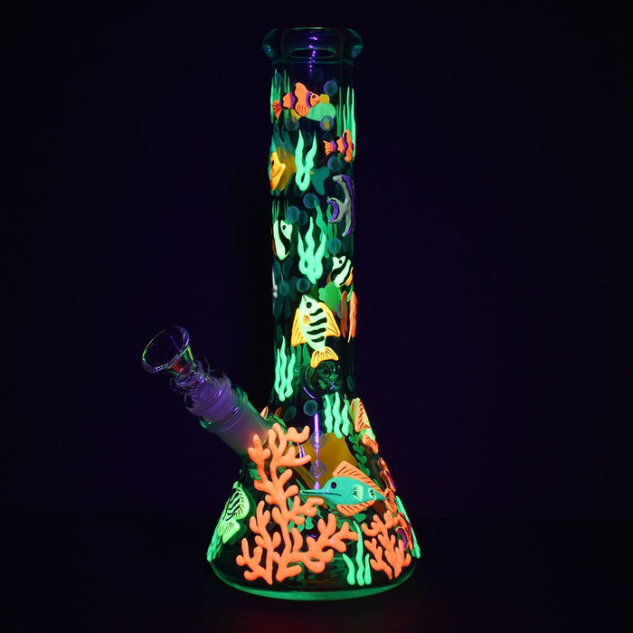 Glowing underwater-themed glass water pipe with fish and coral design on a black background