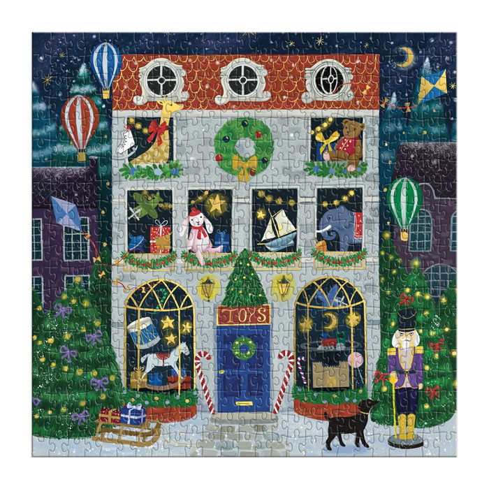The Twilight Toy Shop 500 Piece Foil Puzzle by Bex Parkin features a festive night scene with a decorated toy store, toys in the windows, hot air balloons, nutcracker, wreaths, trees, a black cat outside, and sparkling snow and stars.