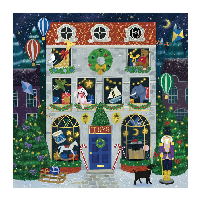 The Bex Parkin Twilight Toy Shop 500 Piece Foil Puzzle features a festive toy shop nestled between Christmas trees, with toys in the windows, a nutcracker and black cat outside, and hot air balloons drifting through a starry night sky.
