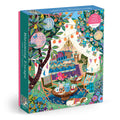 The Victoria Ball Blooming Escape 1000 Piece Puzzle by Victoria Ball features a cozy outdoor tent surrounded by flowers, plants, tea on a table, and colorful decorations in a vibrant garden.