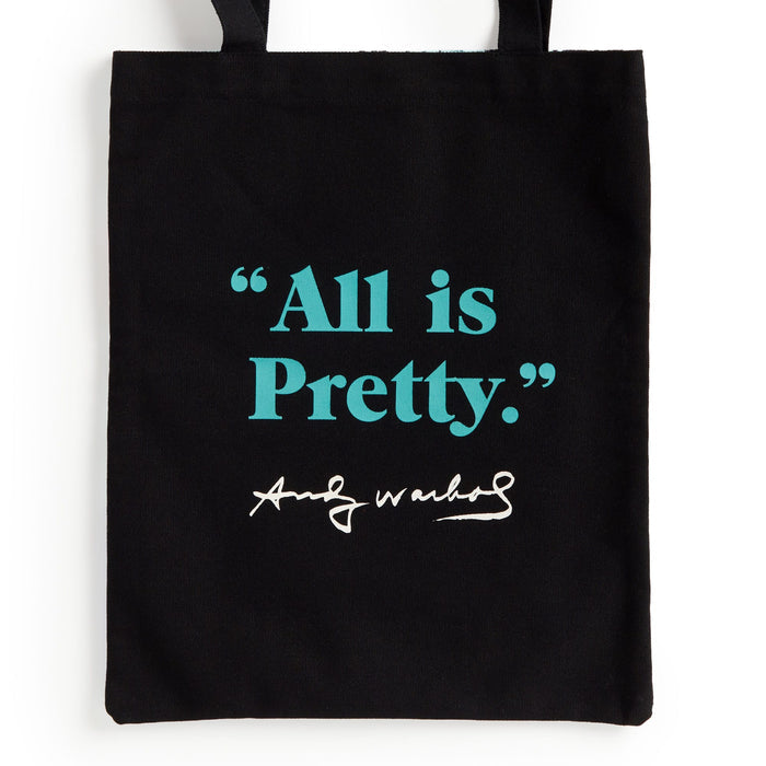 The Warhol Flowers Volume 3 Canvas Tote Bag by Andy Warhol Foundation features “All is Pretty.” in teal with a white Andy Warhol-style signature on a black background.