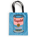 The Warhol Soup Can Volume 3 Canvas Tote Bag by Andy Warhol Foundation For The Visual Arts is a blue tote with black handles, featuring a pop art Campbell’s tomato soup can in pink, blue, yellow, and black.